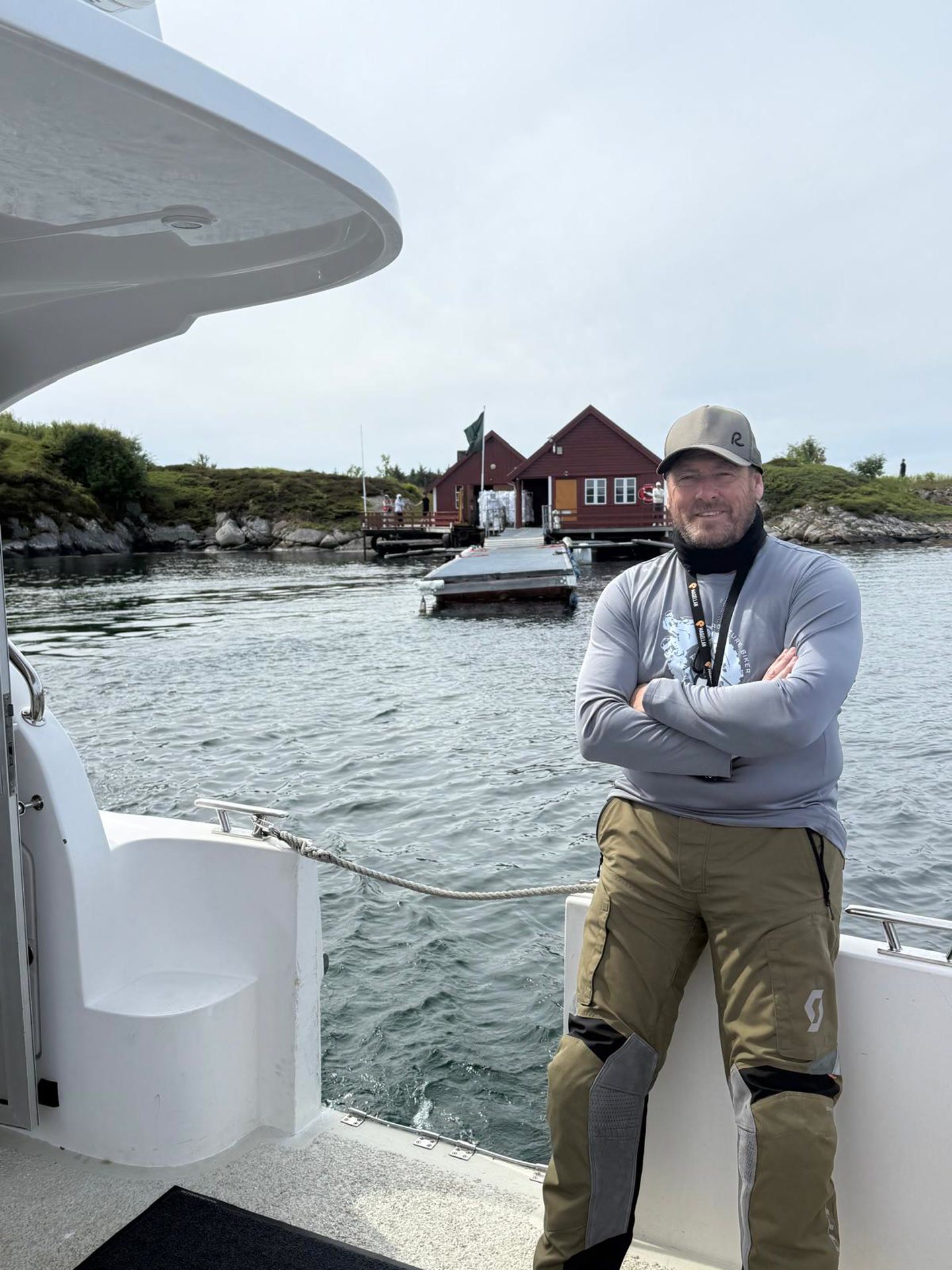 James leaning on a boat rail on a Norwegian fjord