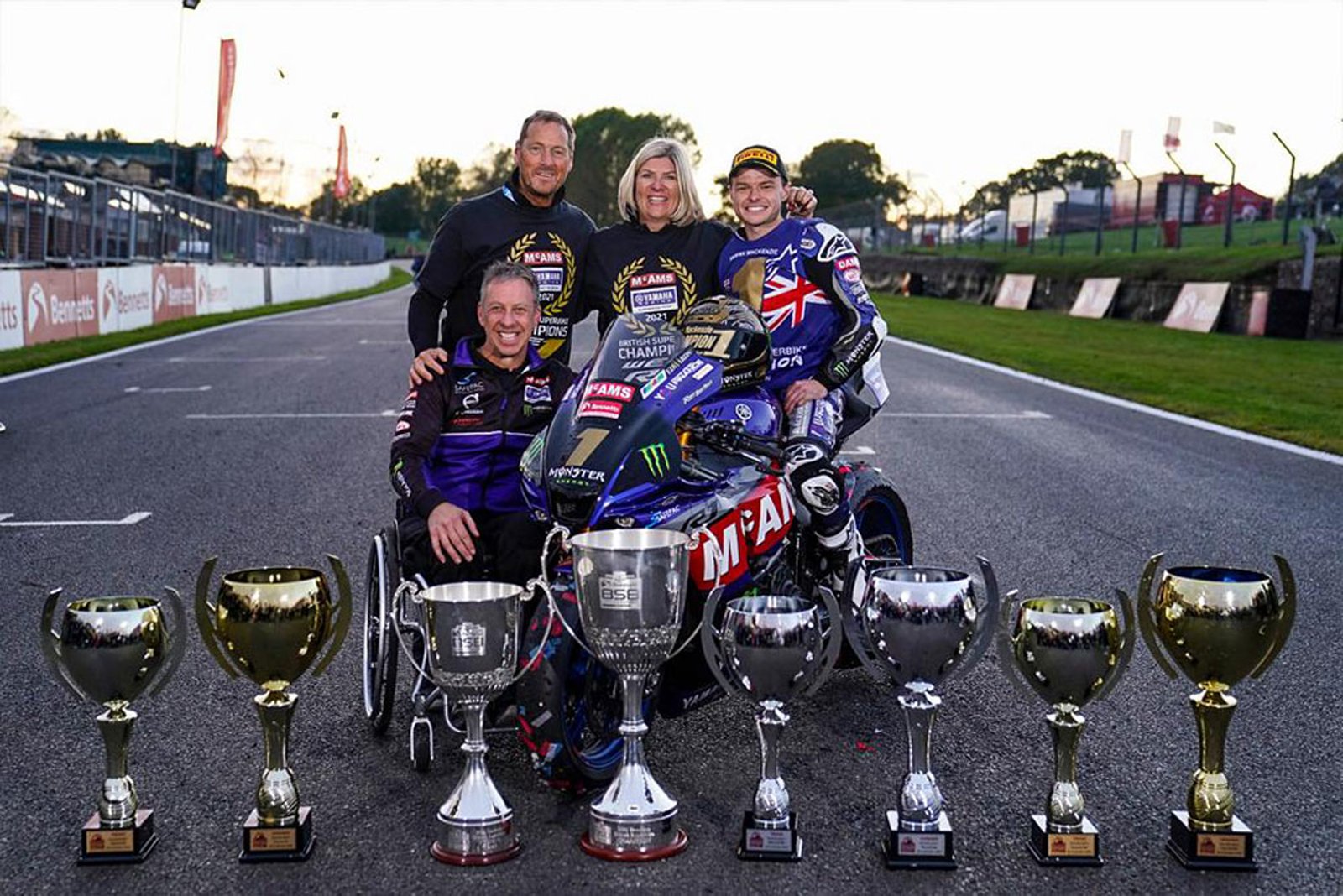 Family photo on the starting grid with the championship winning Yamaha and a row of trophies